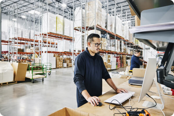 Warehouse worker at the computer / Pracownik magazynowy przy komputerze