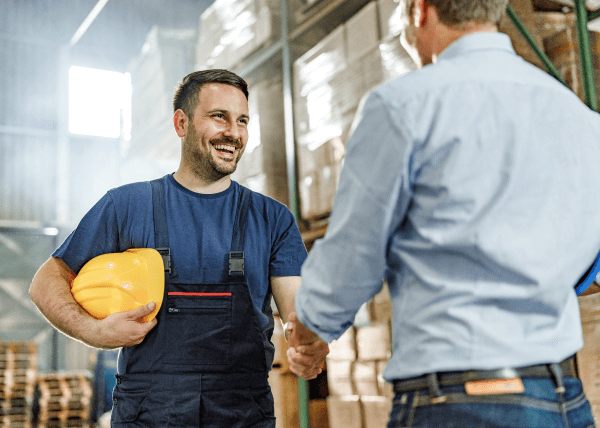 Two man shake hands in warehouse / Dwóch mężczyzn uścisnęło sobie dłoń w magazynie