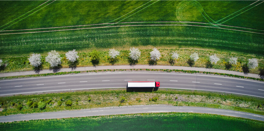 A car driving between green fields / Samochód jadący między zielonymi polami